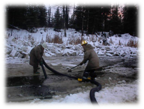 2 workers pumping tailings from pond in winter