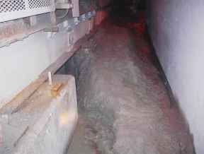 mudded out walkway beside a conveyor in an underground mine