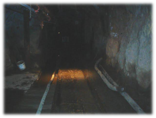 underground mine tunnel with industrial hose on ground