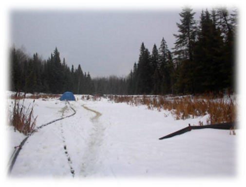 winter scene with blue tent in background and industrial hose in snow