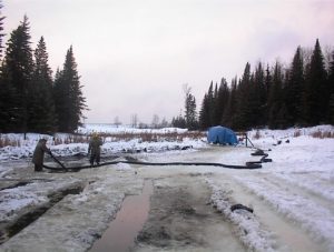 workers with pv500 in background covered by a tarp